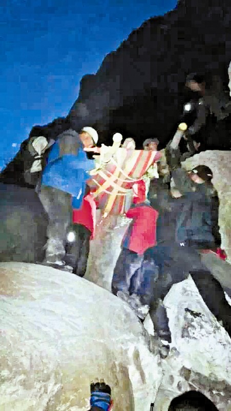 救援隊員用自制的簡易擔(dān)架抬傷者。